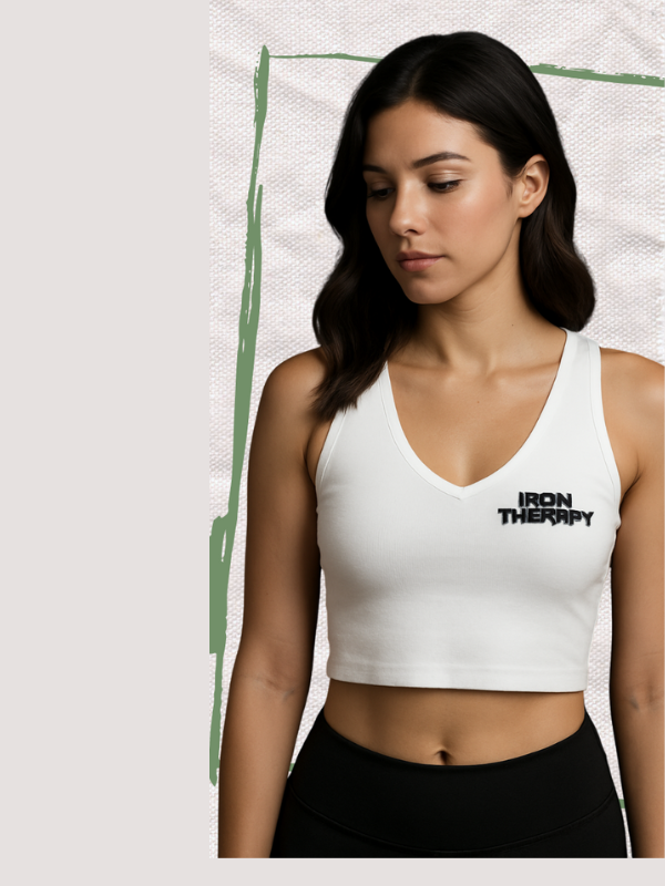 Woman wearing a white sports bra with 'IRON THERAPY' logo on a light background